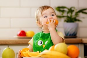 Niña comiendo naranja