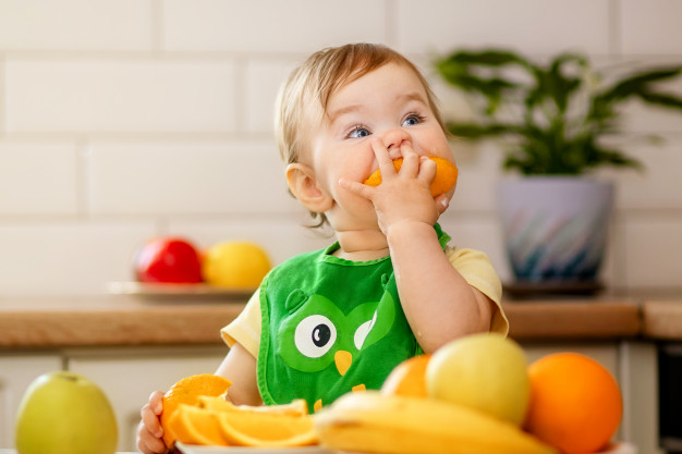 Niña comiendo naranja