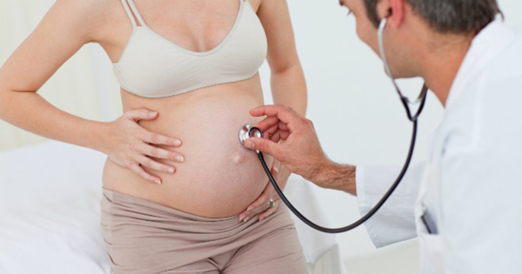 Doctor revisando a mujer embarazada